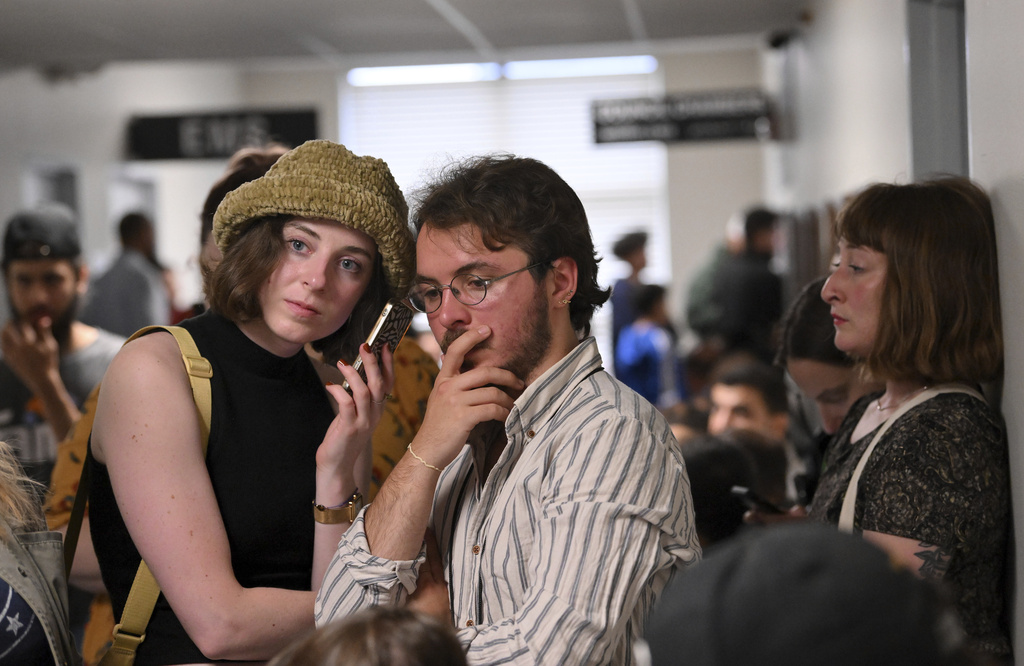 FILE - Emelyn Rutowski, 27, left, and Alessandro Uribe-Rheinbolt, 24, both of Hamtramck, listen in during public comment on the flag neutrality law being considered by the city council in a meeting, from the hallway at City Hall in Hamtramck, Mich., June 13, 2023. (Robin Buckson/Detroit News via AP, File)