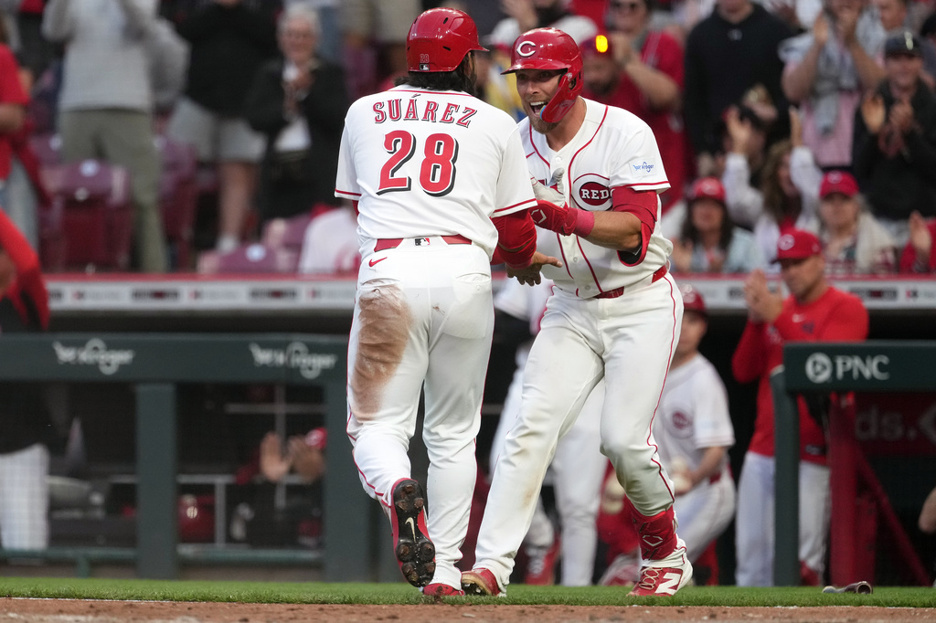 Cincinnati Reds third baseman Eugenio Suárez, left, is congratulated by Cincinnati Reds third baseman Sal Stewart, right, after scoring during the fourth inning of a baseball game against the Pittsburgh Pirates, Monday, March 30, 2026, in Cincinnati. (AP Photo/Kareem Elgazzar)