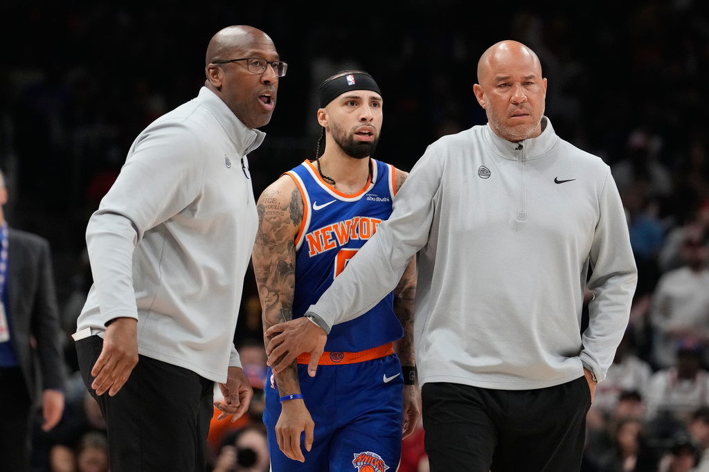 New York Knicks head coach Mike Brown holds back New York Knicks guard Jose Alvarado (5) with another coach during the first half of Game 4 in a first-round NBA playoffs basketball series against the Atlanta Hawks Saturday, April 25, 2026, in Atlanta. (AP Photo/Brynn Anderson)