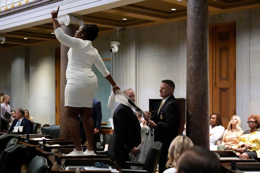 A member of the Senate Sgt.-at-Arms, right, pulls a banner out of the hands of Sen. Charlane Oliver, D-Nashille, as she protests the redrawing of U.S. Congressional voting maps during a special session of the state legislature Thursday, May 7, 2026, in Nashville, Tenn. (AP Photo/George Walker IV)