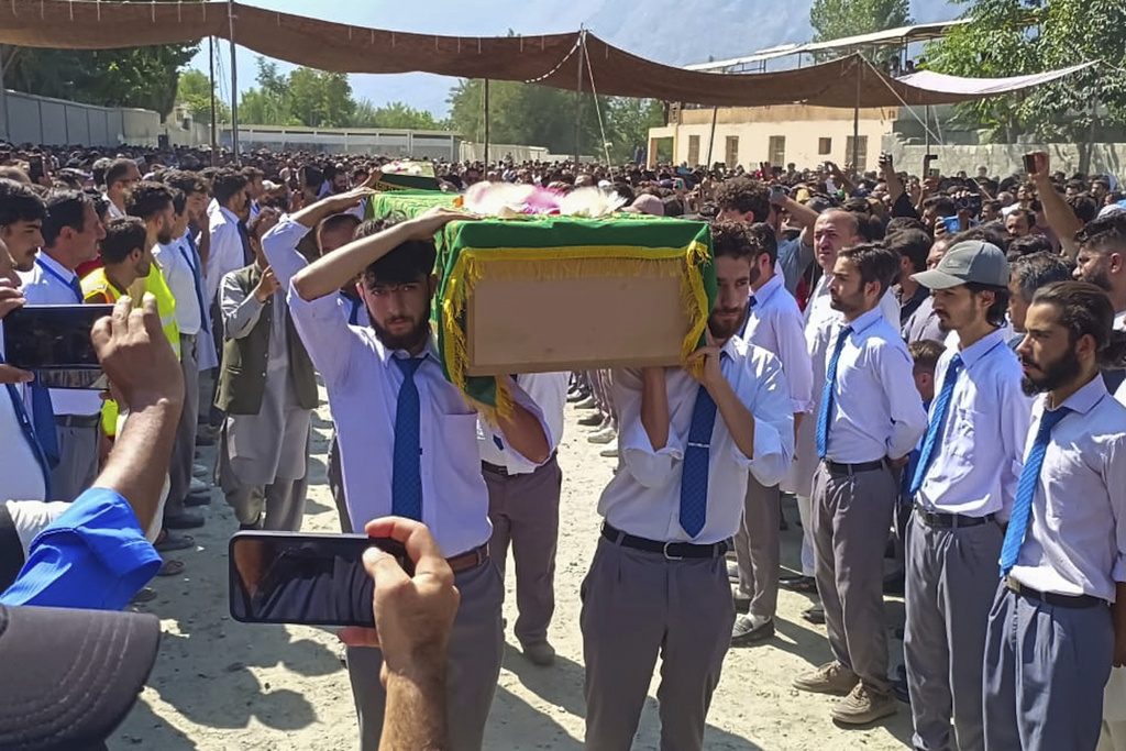 People attend funeral prayer of volunteers who were killed in a massive mudslide when they were repairing a drainage channel damaged by flash floods, in Gilgit, in northern Pakistan, Monday, Aug. 11, 2025. (AP Photo/Abdul Rehman)