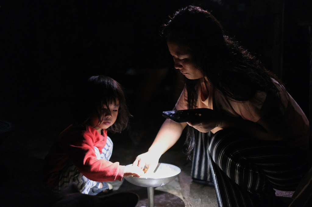 Atoshi Ayemi eats dinner with her daughter Azatina Murru inside their kitchen in Kohima, capital of the northeastern Indian state of Nagaland, Monday, July 6, 2026. (AP Photo/Yirmiyan Arthur)