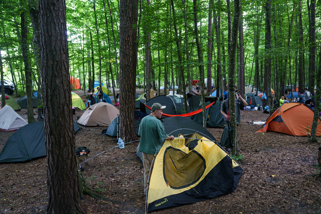 A man installs a tent during the Stoned Climbers festival near Denyshi, Zhytomyr region, Ukraine, Saturday, June 27, 2026. (AP Photo/Evgeniy Maloletka)