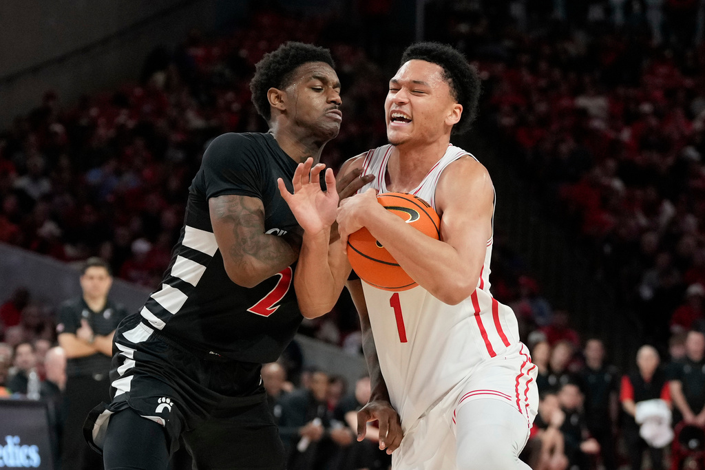 Houston guard Isiah Harwell, right, is fouled by Cincinnati guard Jizzle James, left, during the second half of an NCAA college basketball game Saturday, Jan. 31, 2026, in Houston. (AP Photo/Kevin M. Cox)
