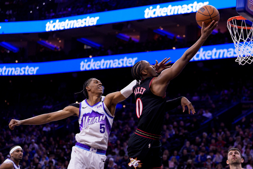 Philadelphia 76ers' Tyrese Maxey, right, goes up for the lay-up against Utah Jazz's Cody Williams, left, during the first half of an NBA basketball game, Wednesday, March 4, 2026, in Philadelphia. (AP Photo/Chris Szagola)
