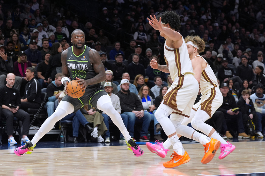 Minnesota Timberwolves forward Julius Randle (30) looks to shoot as Golden State Warriors forward Gui Santos, second from right, and guard Brandin Podziemski, right, defend during the first half of an NBA basketball game, Monday, Jan. 26, 2026, in Minneapolis. (AP Photo/Abbie Parr)
