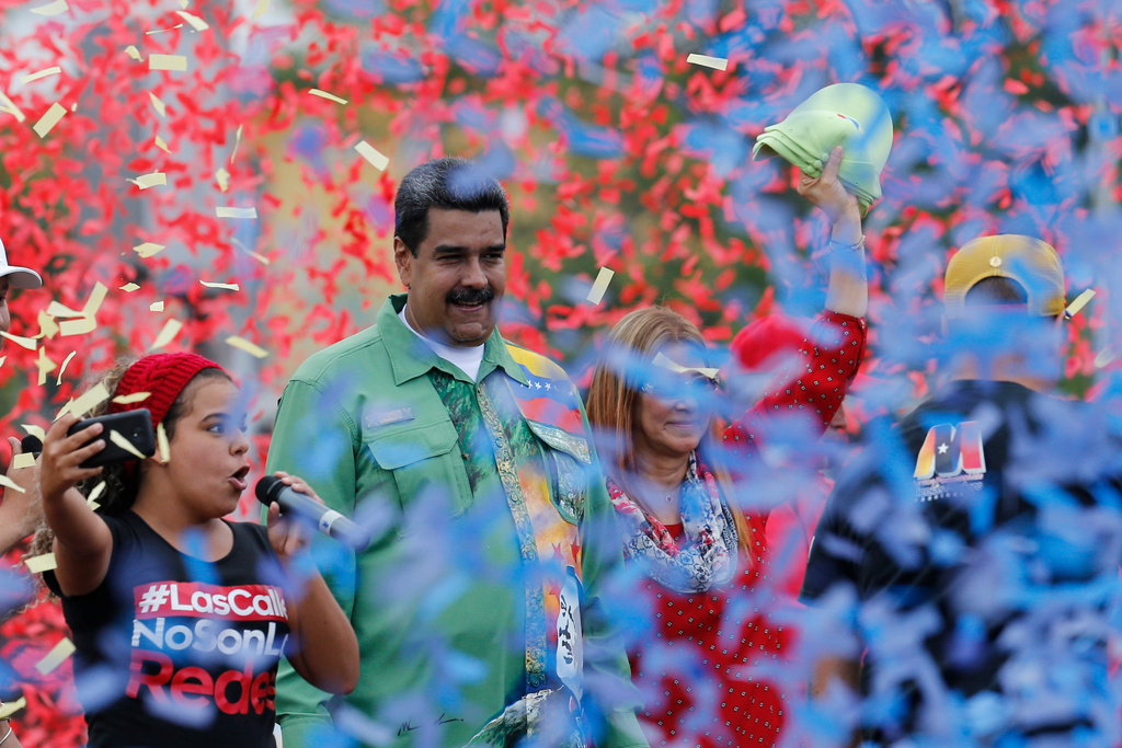 FILE - Venezuela's President Nicolas Maduro stands with his wife, first lady Cilia Flores, right, in a shower of confetti during his closing campaign rally for reelection in Caracas, Venezuela, May 17, 2018. Maduro was seeking a new six-year mandate amid crippling hyperinflation and widespread shortages of food and medicine. (AP Photo/Ariana Cubillos, File)