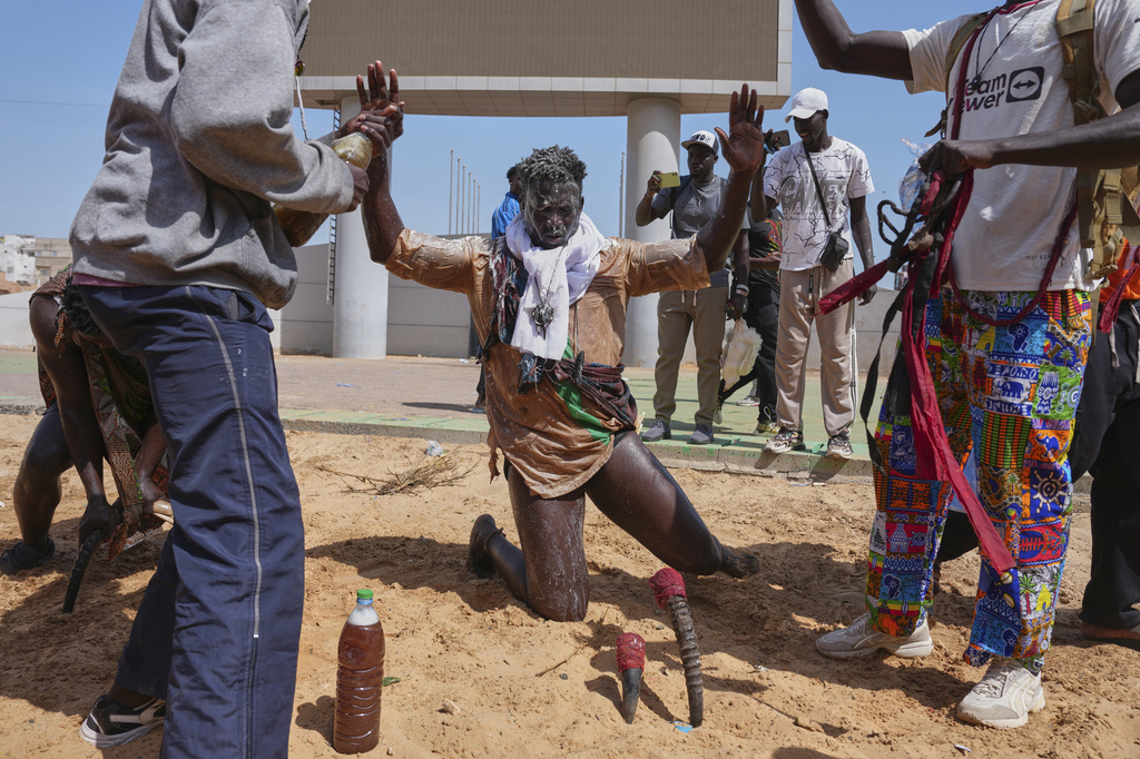A wrestler performs rituals ahead of a wrestling match at the national wrestling arena in Dakar, Senegal, Sunday, March 29, 2026. (AP Photo/Misper Apawu)