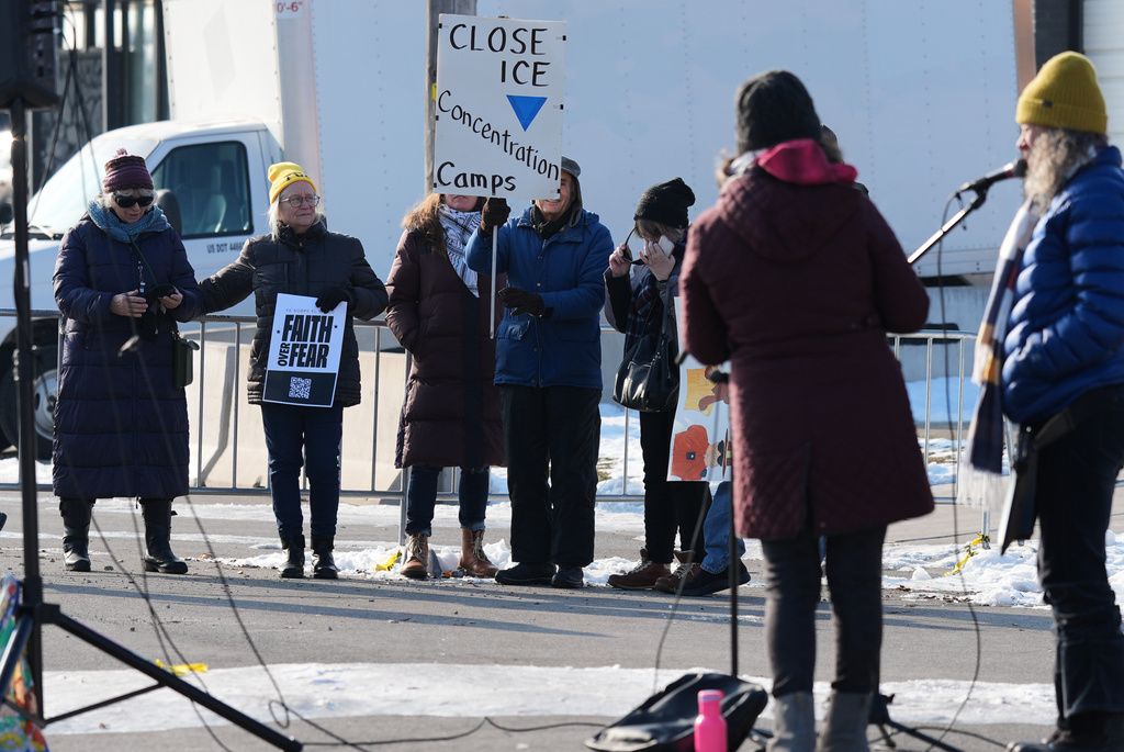Protesters gather as Law enforcement officers guard outside an ICE processing facility in the Chicago suburb of Broadview, Ill., Friday, Dec. 12, 2025. (AP Photo/Nam Y. Huh)