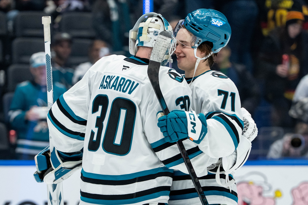 San Jose Sharks goaltender Yaroslav Askarov (30) and Macklin Celebrini (71) celebrate after defeating the Vancouver Canucks in an NHL hockey game in Vancouver, British Columbia, Saturday, Dec. 27, 2025. (Ethan Cairns/The Canadian Press via AP)