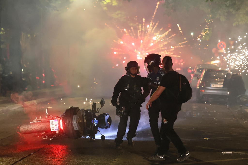 Police try to disperses PSG supporters who left off fireworks as they celebrate in Paris, Saturday, May 30, 2026 after the Champions League final soccer match between Paris Saint-Germain and Arsenal that was played in Budapest, PSG won the game. (AP Photo/Thomas Padilla)