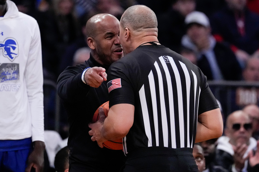 Seton Hall head coach Shaheen Holloway, left, argues with a referee, right, during the first half of an NCAA college basketball game against St. John's in the semifinals of the Big East tournament, Friday, March 13, 2026, in New York. (AP Photo/Yuki Iwamura)