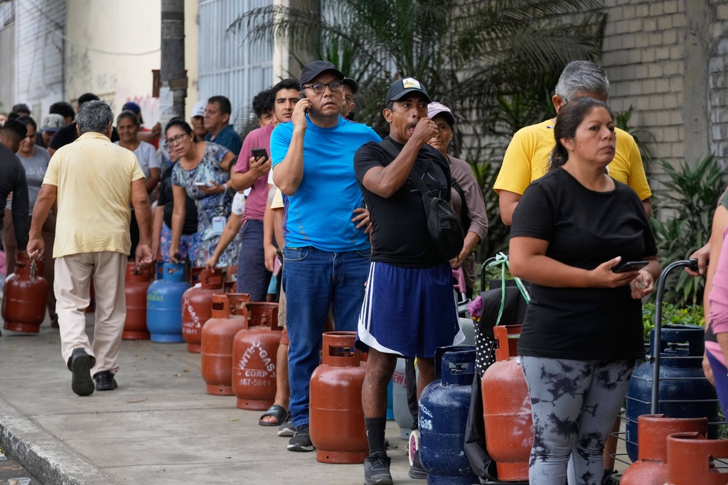 People wait to buy natural gas for cooking while authorities ration it due to a main gas pipeline that ruptured and affected supply to Lima, Peru, Wednesday, March 11, 2026. (AP Photo/Martin Mejia)