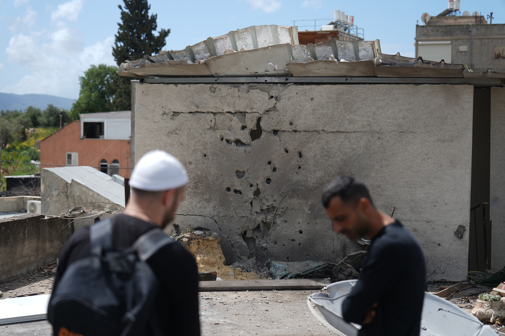 Residents inspect a damaged house following an Iranian missile strike in Shefaram Israel, Monday, March 30, 2026. (AP Photo/Ariel Schalit)