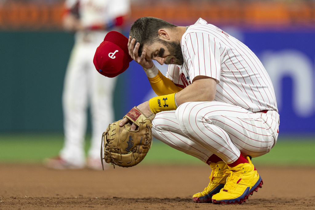 Philadelphia Phillies first baseman Bryce Harper reacts to not being able to catch Atlanta Braves' Michael Harris on a pickoff play during the fifth inning of a baseball game, Sunday, Aug. 31, 2025, in Philadelphia. (AP Photo/Chris Szagola)