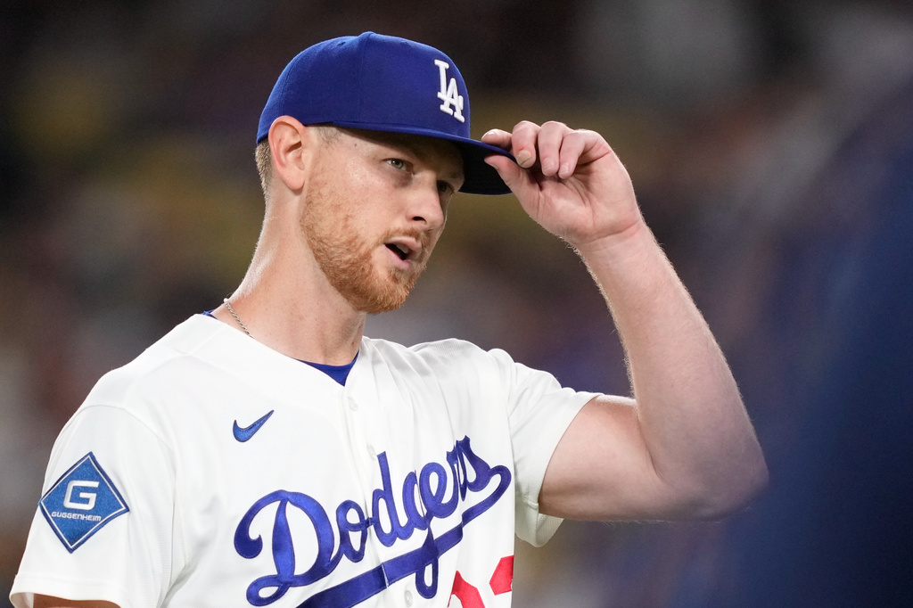 Los Angeles Dodgers starting pitcher Eric Lauer adjusts his cap while the crowd applauds as he walks off the field after being relieved during the seventh inning of a baseball game against the Kansas City Royals, Wednesday, Aug. 12, 2026, in Los Angeles. (AP Photo/Mark J. Terrill)