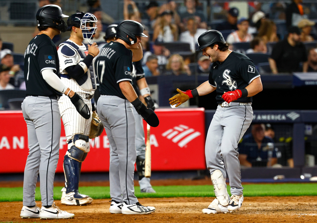 Chicago White Sox designated hitter Andrew Benintendi, right, celebrates with Jacob Gonzalez after hitting a grand slam against the New York Yankees during the eighth inning of a baseball game, Thursday, June 18, 2026, in New York. (AP Photo/Noah K. Murray)