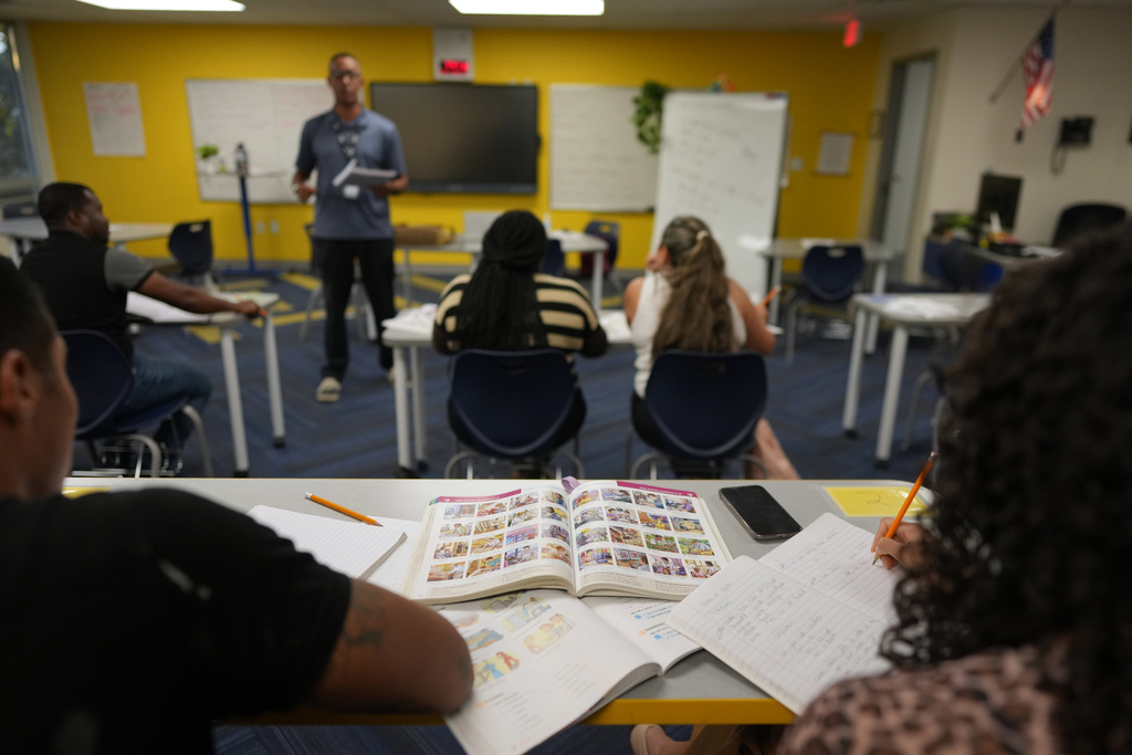 Immigrants trying to learn the English language take notes as Eliezer Guerrero of Catholic Charities of Central Florida teaches an ESOL class, Tuesday, Aug. 19, 2025, in Orlando, Fla. (AP Photo/Rebecca Blackwell)
