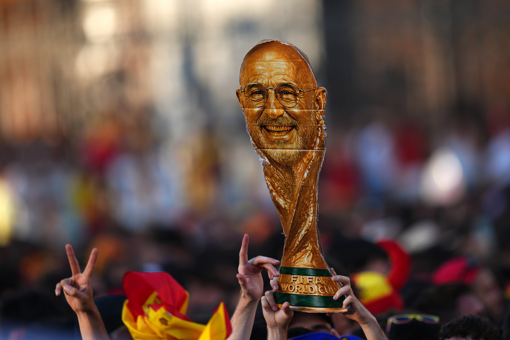 A fan holds up an image of Spain's head soccer coach Luis de la Fuente as a crowd awaits the arrival of players from Spain's national soccer team during celebrations in Madrid on Monday, July 20, 2026, after Spain defeated Argentina in the World Cup final in East Rutherford, N.J., near New York. (AP Photo/Manu Fernandez)
