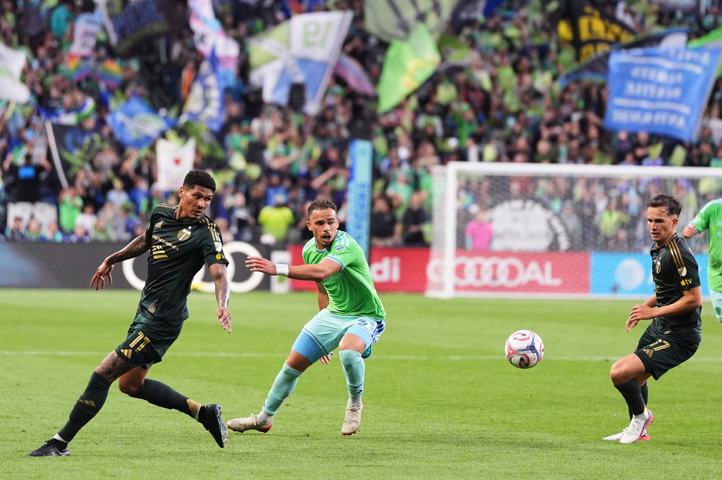Seattle Sounders defender Hassani Dotson, center, loses the ball against Portland Timbers forward Antony, left, and midfielder Cole Bassett, right, during the first half of an MLS soccer match, Thursday, July 16, 2026, in Seattle. (AP Photo/Lindsey Wasson)