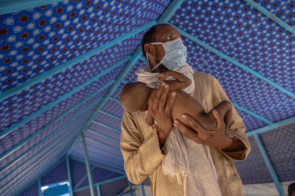 Nurse Mohamed Ag Tidaba holds a malnourished baby from Mali at the health clinic in Douankara, Hodh El Chargui Region, Mauritania, Nov. 7, 2025. (AP Photo/Caitlin Kelly)