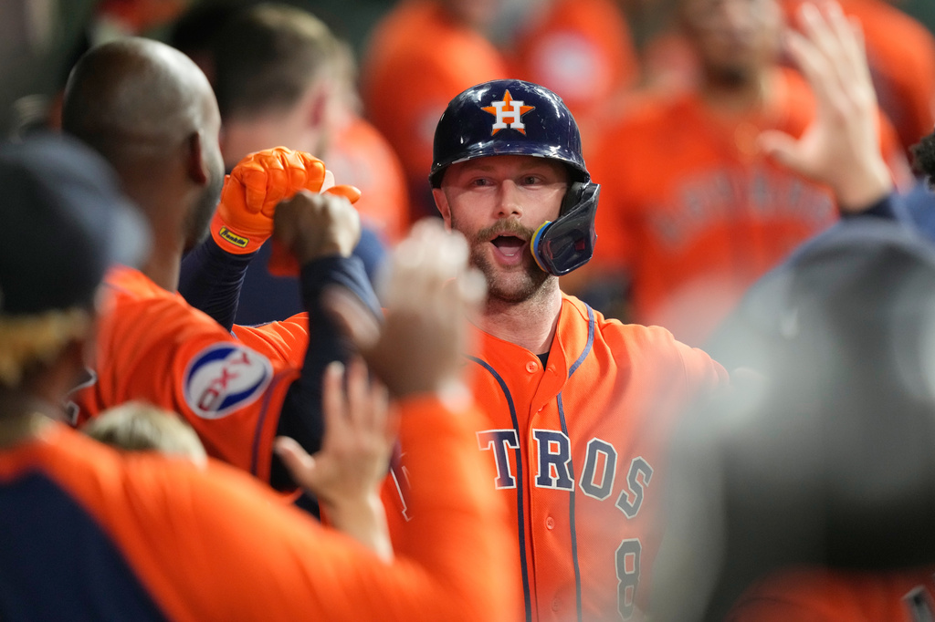Houston Astros' Christian Walker celebrates in the dugout after hitting a home run against the Texas Rangers during the fifth inning of a baseball game Friday, July 31, 2026, in Houston. (AP Photo/David J. Phillip)