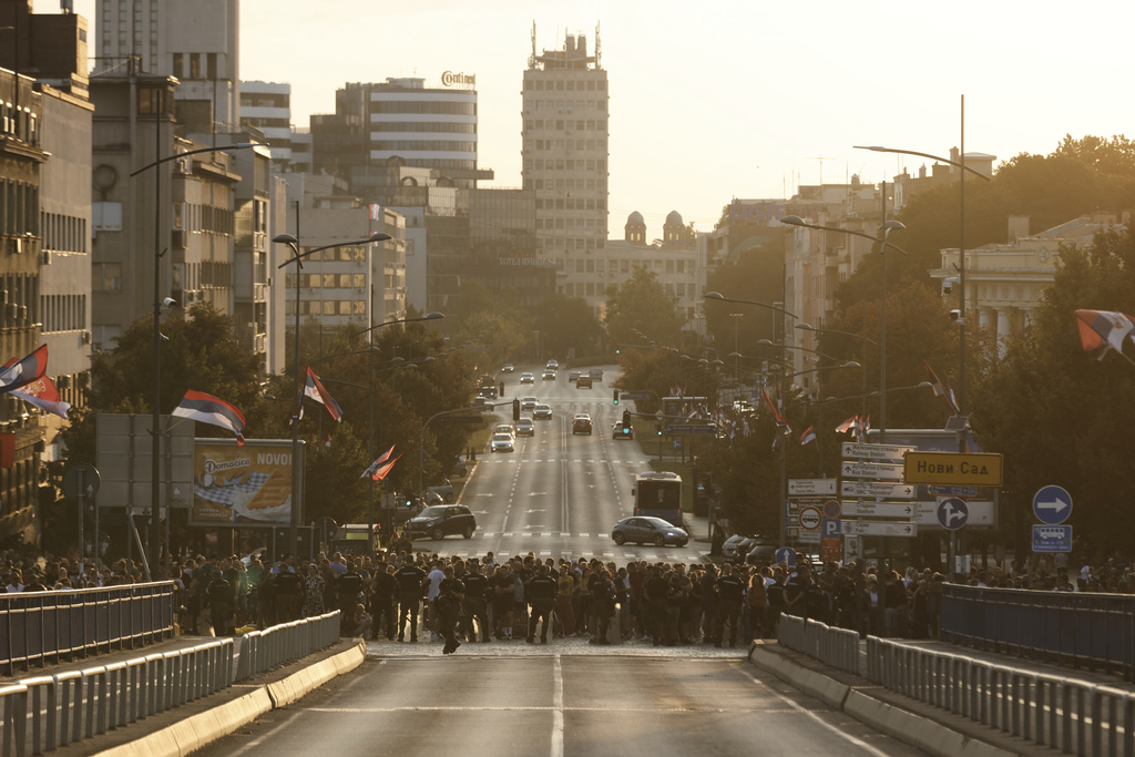 Serbian gendarmerie officers block a bridge to separate anti-government protesters, front, and supporters of Serbian President Aleksandar Vucic in Novi Sad, Serbia, Saturday, Sept. 13, 2025. (AP Photo/Marko Drobnjakovic)