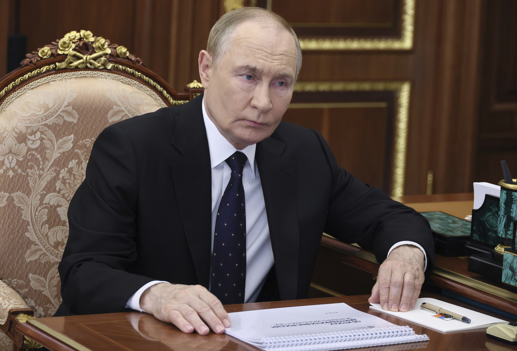 Russian President Vladimir Putin listens to the head of the Federal Taxation Service Daniil Yegorov during their meeting at the Kremlin in Moscow, Russia, on Wednesday, Aug. 13, 2025. (Vyacheslav Prokofyev, Sputnik, Kremlin Pool Photo via AP)