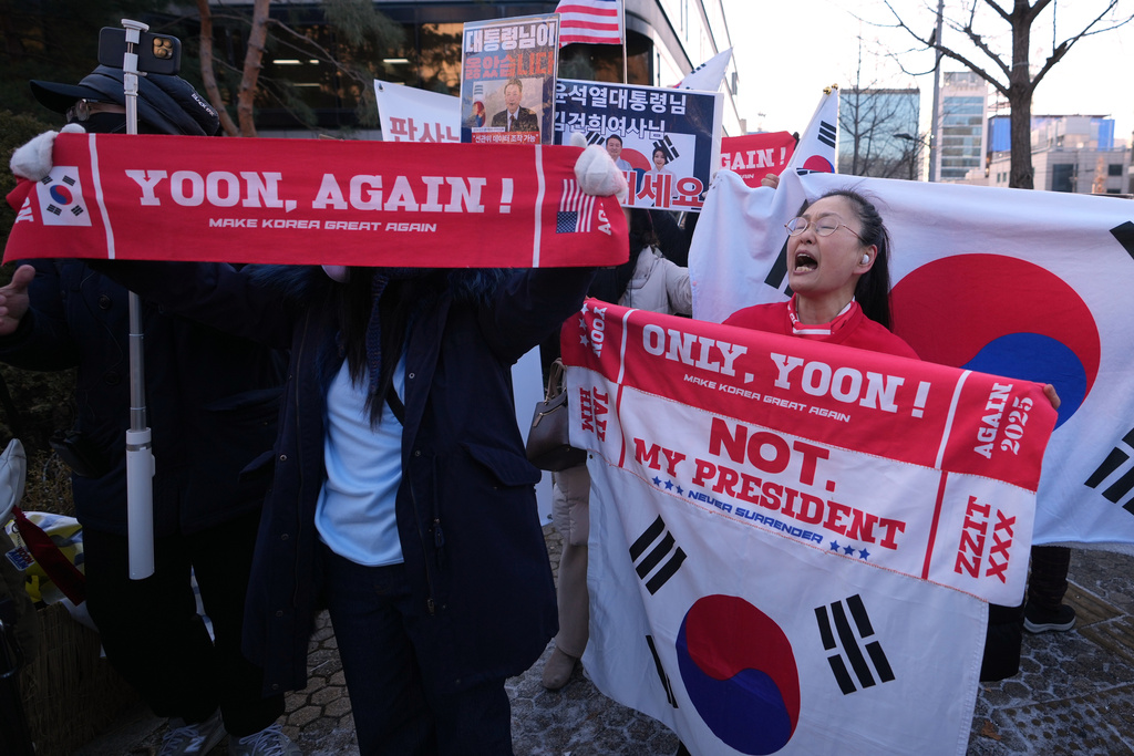 Supporters of former South Korean President Yoon Suk Yeol hold signs outside of Seoul Central District Court, in Seoul, South Korea, Tuesday, Jan. 13, 2026. (AP Photo/Lee Jin-man)
