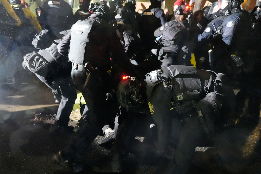 Law enforcement move to detain a protester outside the U.S. Immigration and Customs Enforcement facility on Thursday, Jan. 8, 2026, in Portland, Ore. (AP Photo/Jenny Kane)