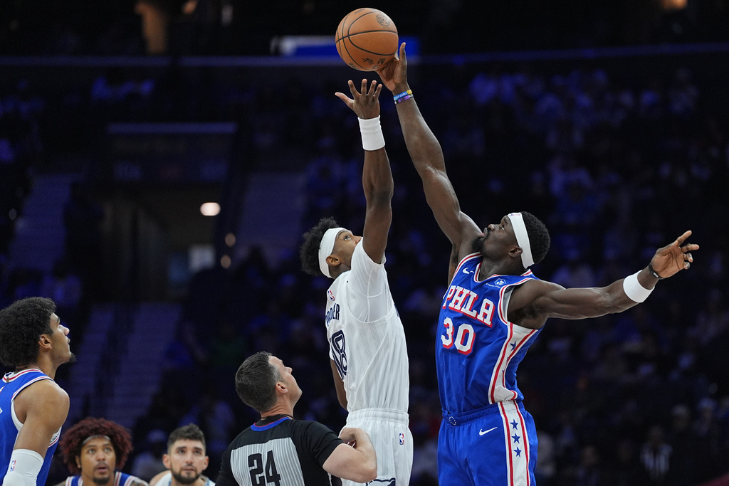 Philadelphia 76ers' Adem Bona (30) tips the ball past Memphis Grizzlies' Olivier-Maxence Prosper during the first half of an NBA basketball game Tuesday, March 10, 2026, in Philadelphia. (AP Photo/Matt Rourke)