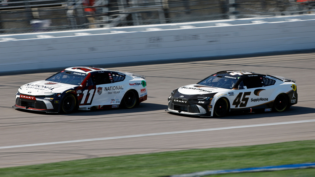 Denny Hamlin (11) and Tyler Reddick (45) head down the front straightaway during the third stage of a NASCAR Cup Series auto race at Kansas Speedway in Kansas City, Kan., Sunday, April 19, 2026. (AP Photo/Colin E. Braley)
