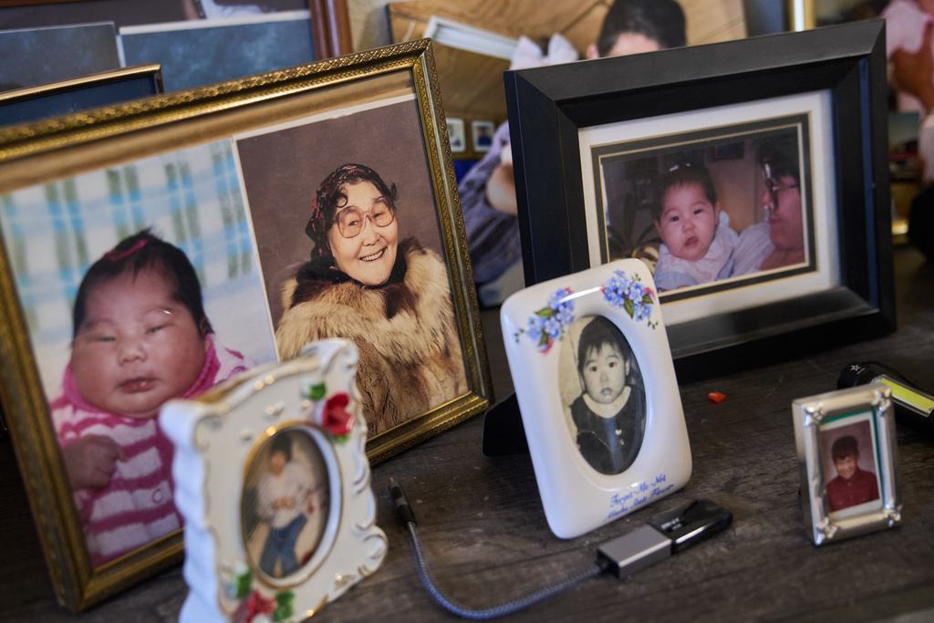Family photos of the Paul family that were salvaged from their home sit on Louise Paul's dresser in Bethel, Alaska, Tuesday, Oct. 28, 2025, after they were displaced from their village of Kipnuk, Alaska by Typhoon Halong. (AP Photo/Lindsey Wasson)