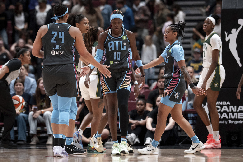Atlanta Dream's Rhyne Howard (10) celebrates with teammates after scoring against the Seattle Storm during the first half of a WNBA basketball game in Vancouver, British Columbia, on Friday, Aug. 15, 2025. (Ethan Cairns/The Canadian Press via AP)