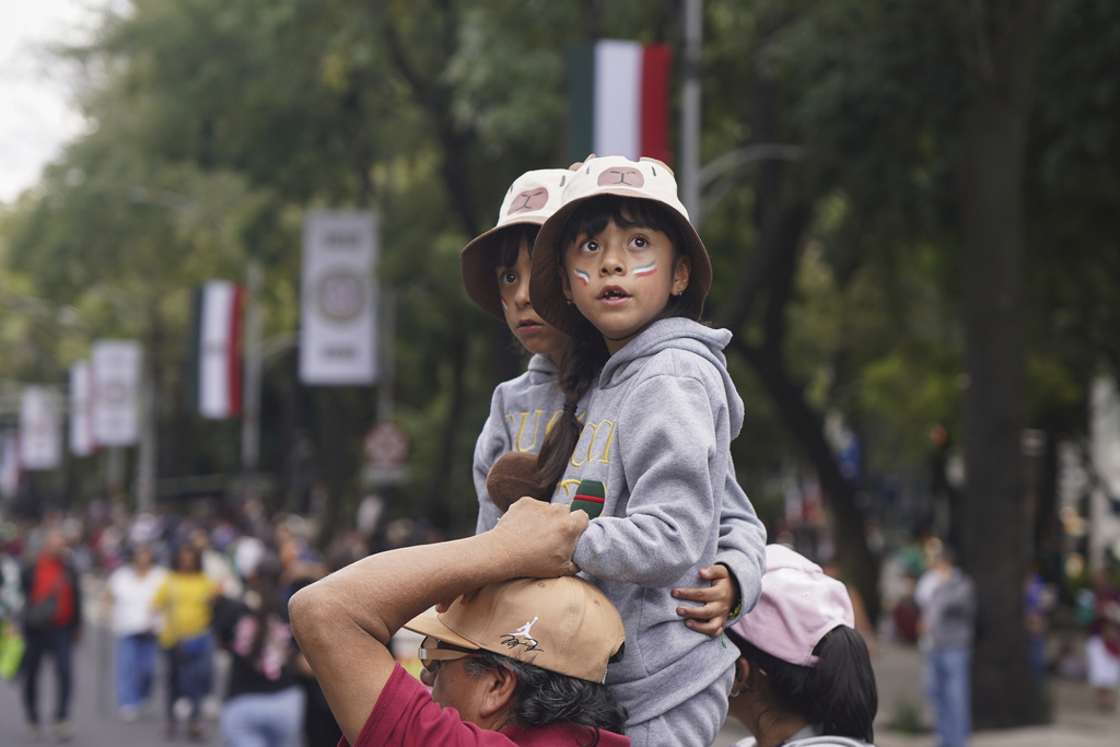 Children look out at the Independence Day military parade along Reforma Ave. in Mexico City, Tuesday, Sept. 16, 2025. (AP Photo/Jon Orbach)