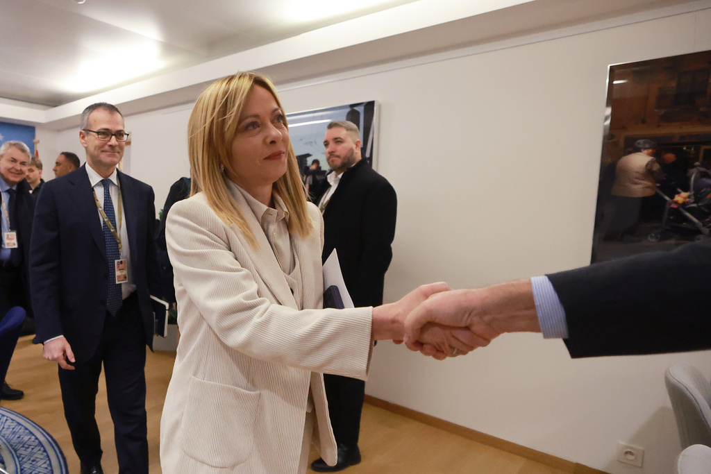 Italy's Prime Minister Giorgia Meloni, center, is greeted as she arrives for a round table meeting on migration at the EU Summit in Brussels, Thursday, Dec. 18, 2025. (AP Photo/Olivier Hoslet, Pool Photo via AP)