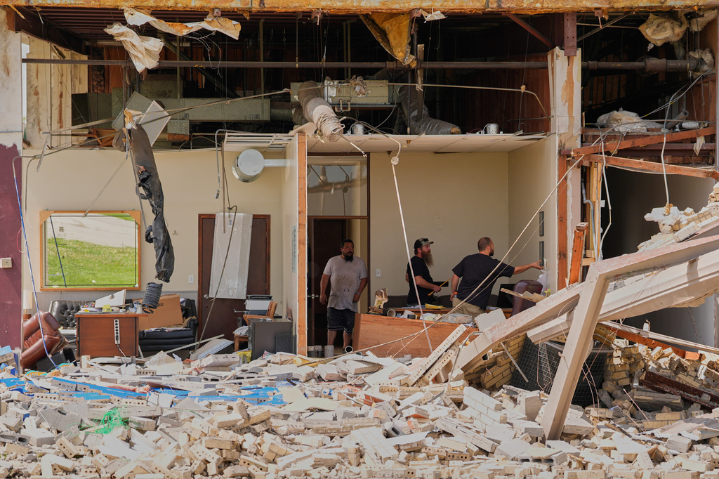 Workers salvage items Tuesday, April 14, 2026, at a pipe manufacturing facility that was damaged by a tornado Monday in Ottawa, Kan. (AP Photo/Charlie Riedel)