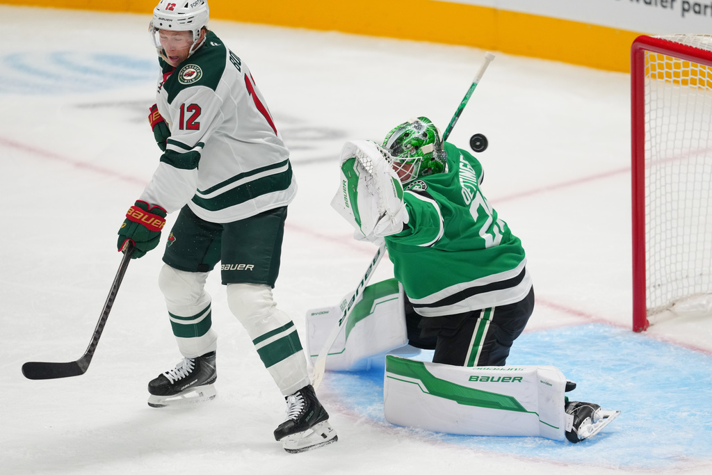 Minnesota Wild left wing Matt Boldy (12) scores a goal on Dallas Stars goaltender Jake Oettinger during the third period of an NHL hockey game Tuesday, Oct. 14, 2025, in Dallas. (AP Photo/Julio Cortez)