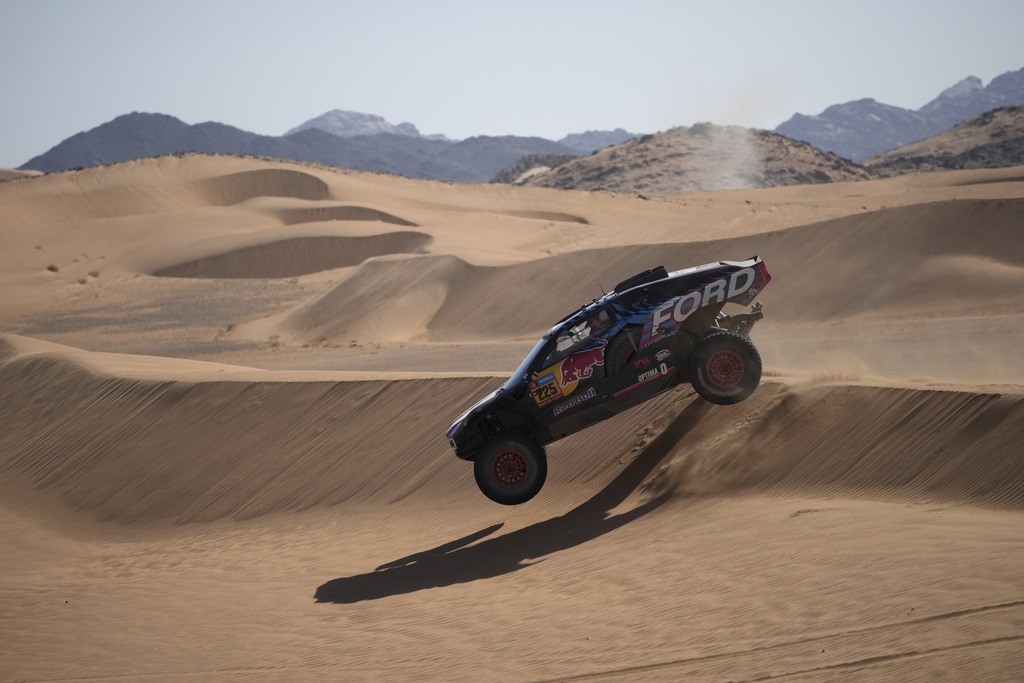 Driver Carlos Sainz and co-driver Lucas Cruz compete during the stage two, day One, of the Dakar Rally with start in Bisha and finish in Bisha, Saudi Arabia, Sunday, Jan. 5, 2025. (AP Photo/Christophe Ena)