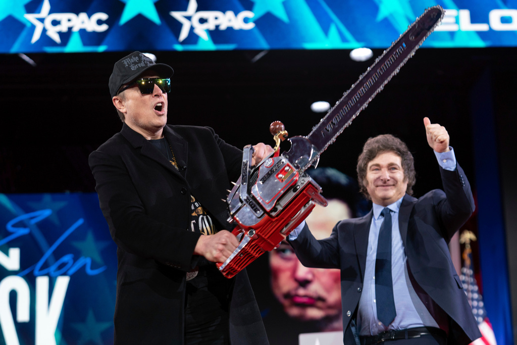FILE - Elon Musk holds up a chainsaw he received from Argentina's President Javier Milei, right, as they arrive to speak at the Conservative Political Action or CPAC Conference in Oxon Hill, Md. (AP Photo/Jose Luis Magana, File)