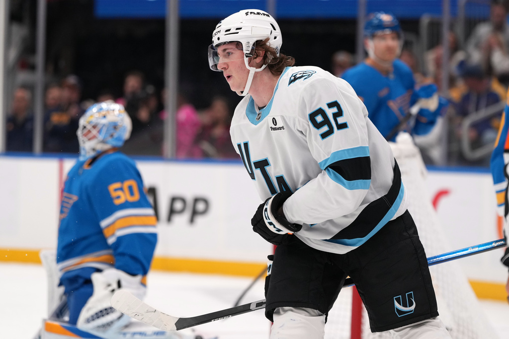 Utah Mammoth's Logan Cooley (92) celebrates after scoring past St. Louis Blues goaltender Jordan Binnington (50) for his third goal of the first period of an NHL hockey game Thursday, Oct. 23, 2025, in St. Louis. (AP Photo/Jeff Roberson)