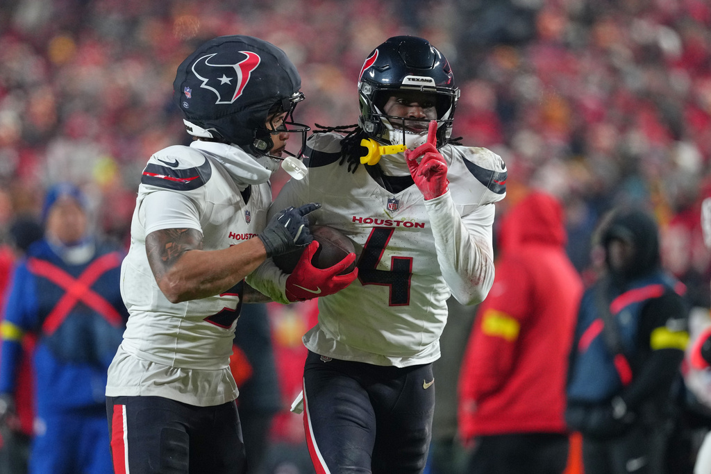 Houston Texans cornerback Kamari Lassiter (4) is congratulated by teammate Jalen Pitre, left, after intercepting a pass during the second half of an NFL football game against the Kansas City Chiefs Sunday, Dec. 7, 2025, in Kansas City, Mo. (AP Photo/Ed Zurga)