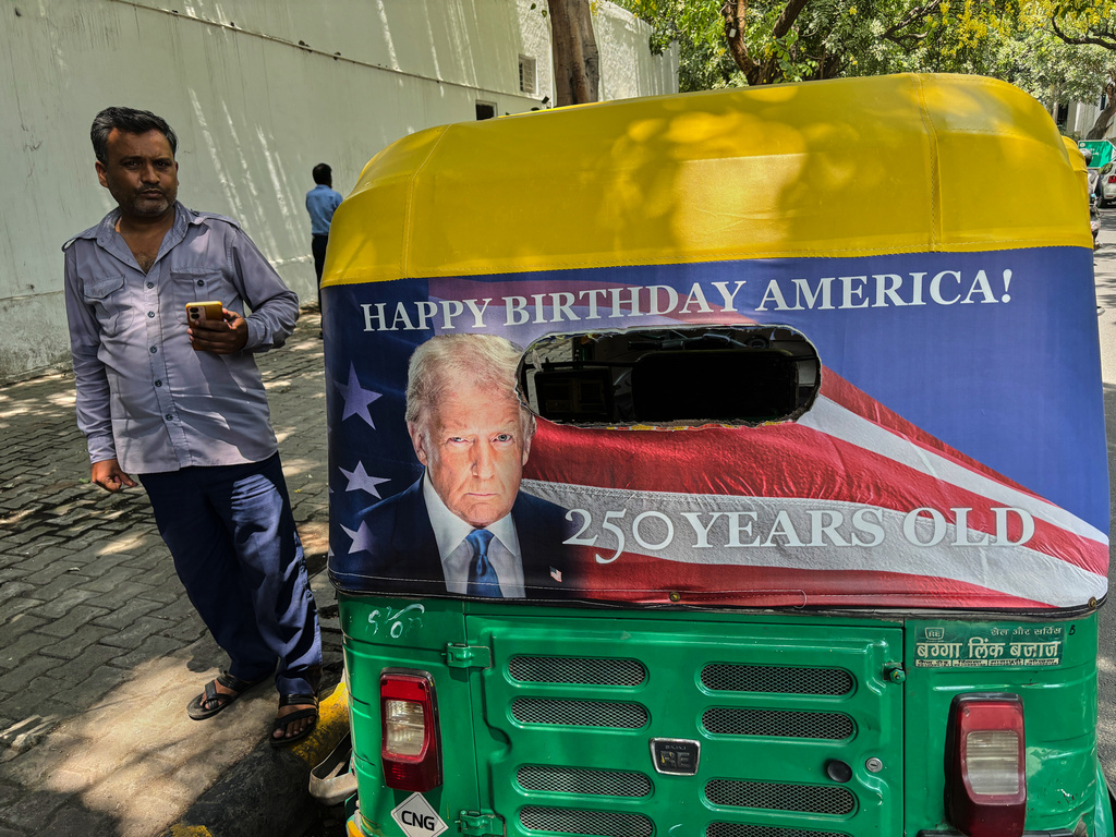Pradeep Kumar stands next to his auto-rickshaw featuring a poster of U.S. President Donald Trump that celebrates "250 Years of America" on the back of his vehicle in New Delhi, India, Wednesday, May 20, 2026. (AP Photo/Shonal Ganguly)