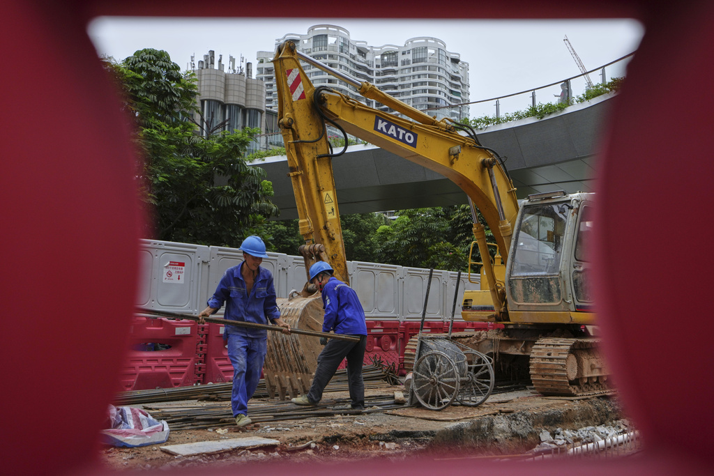 Workers transfer materials at a construction site for a new pedestrian overhead bridge, at the Shenzhen Bay commercial district, in Shenzhen, China's Guangdong province, Friday, Sept. 19, 2025. (AP Photo/Andy Wong)