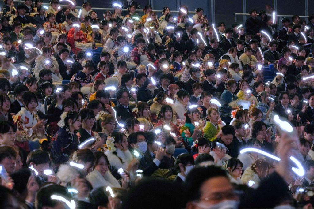 Young adults hold up their lighted mobile phones to celebrate the Coming-of-Age Day, a centuries-old tradition and national holiday marking the milestone from childhood to adulthood, Monday, Jan. 12, 2026, in Yokohama near Tokyo. (AP Photo/Eugene Hoshiko)