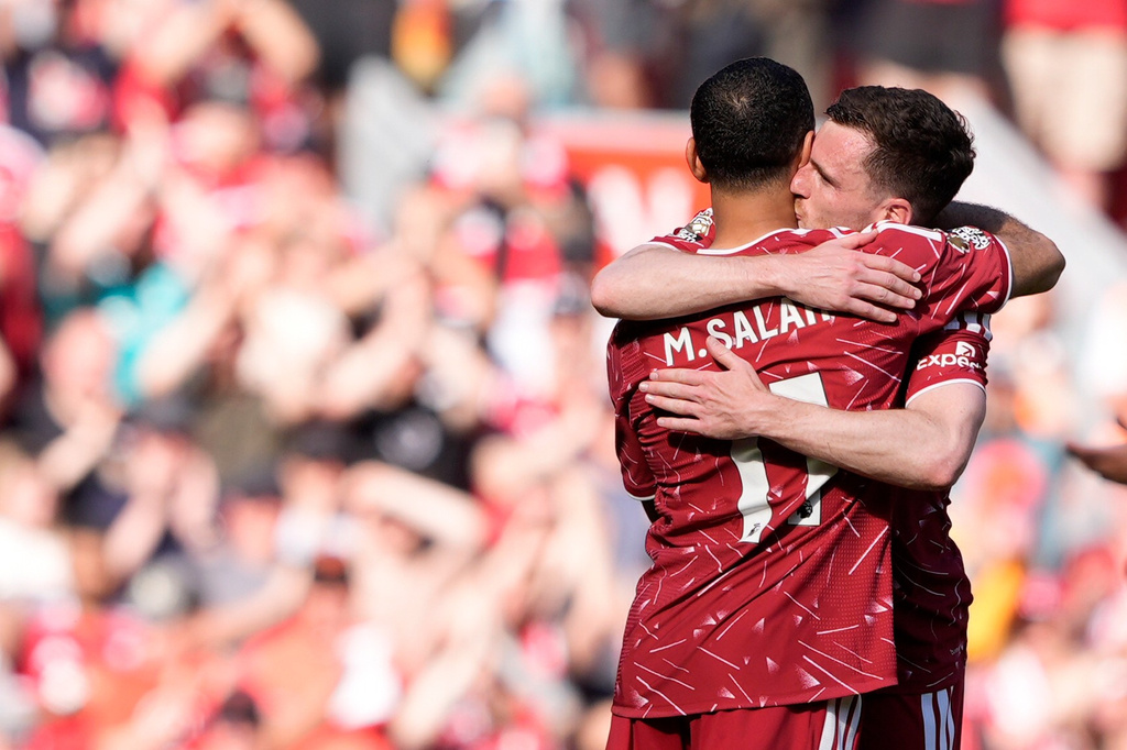Liverpool's Mohamed Salah, back to the camera, hugs team-mate Liverpool's Andrew Robertson as he is substituted off on his final appearance during the Premier League match between Liverpool and Brentford, in Liverpool, England, Sunday May 24, 2026. (Peter Byrne/PA via AP)