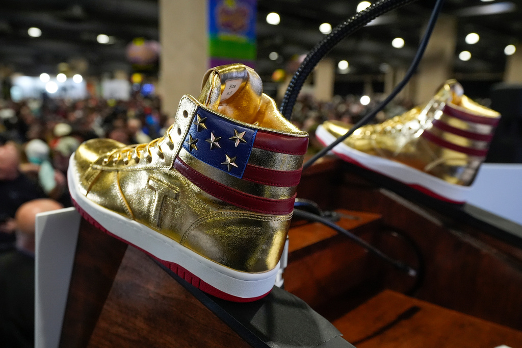 FILE - Gold Trump sneakers sit on the podium after Republican presidential candidate former President Donald Trump spoke at Sneaker Con Philadelphia, an event popular among sneaker collectors, and announces a gold Trump sneaker, in Philadelphia, Saturday, Feb. 17, 2024. (AP Photo/Manuel Balce Ceneta, File)