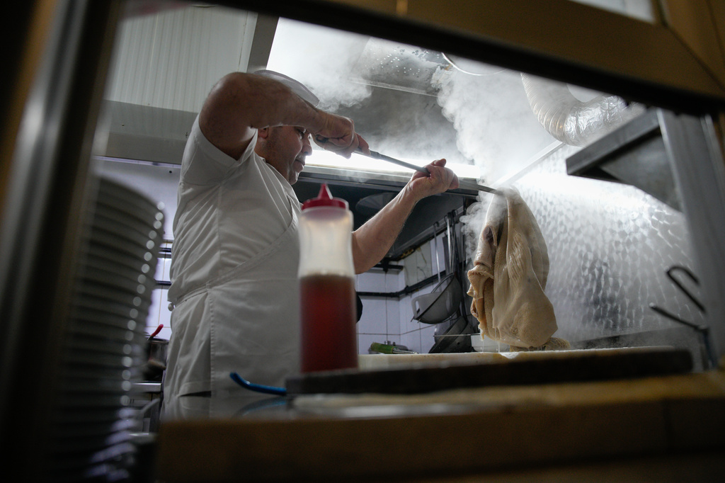 A man cooks traditional tripe soup, known as "iskembe" in Turkish and "patsas" in Greek, in a restaurant in Istanbul, Turkey, Friday, March 27, 2026. (AP Photo/Emrah Gurel)