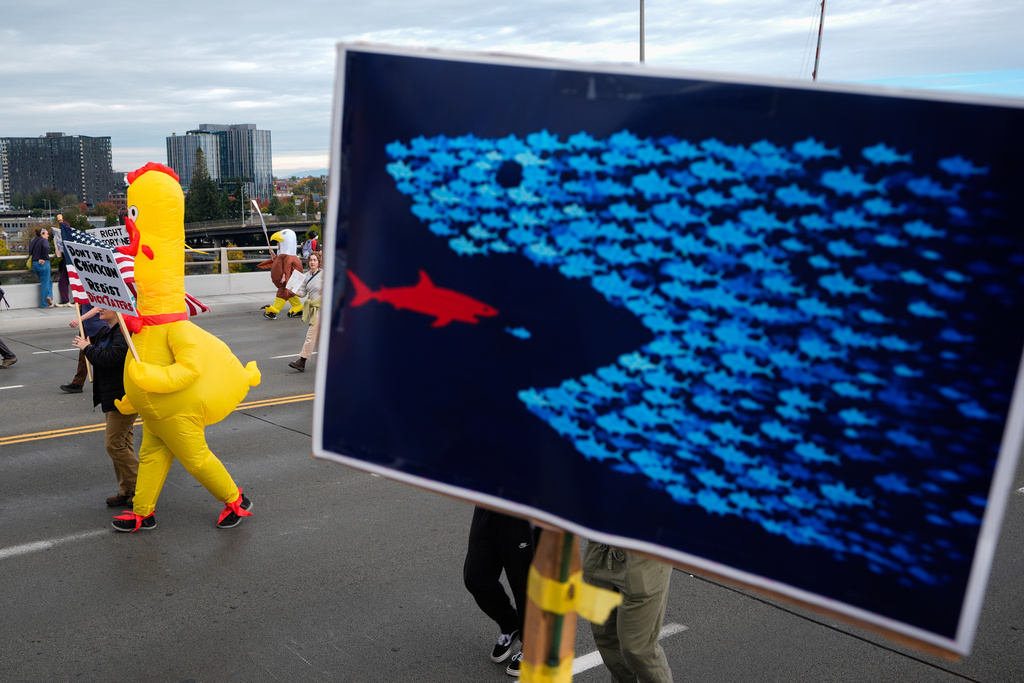 People walk across the Morrison Bridge during a "No Kings" protest Saturday, Oct. 18, 2025, in Portland, Ore. (AP Photo/Jenny Kane)