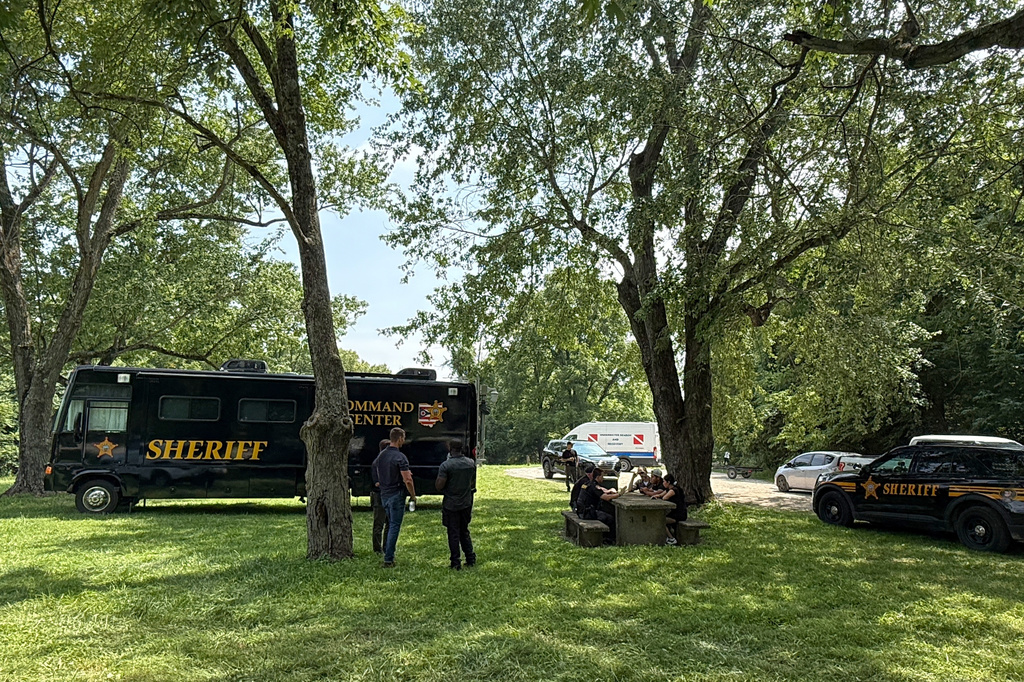 Officials stand at a staging area after an operation to recover multiple people who died while trying to save someone from the Scioto River in the Columbus suburb of Powell, Ohio, Monday, July 20, 2026. (AP Photo/Patrick Aftoora-Orsagos)